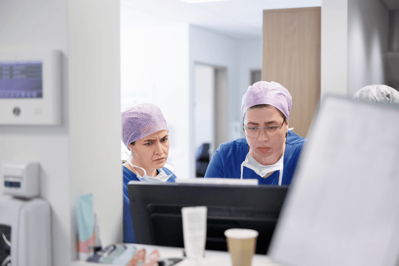 Two surgeons analyzing medical charts on computer monitor in hospital - stock photo
Two surgeons analyzing medical charts on computer monitor in hospital. Female medical professionals in scrubs using computer in medical examination room.